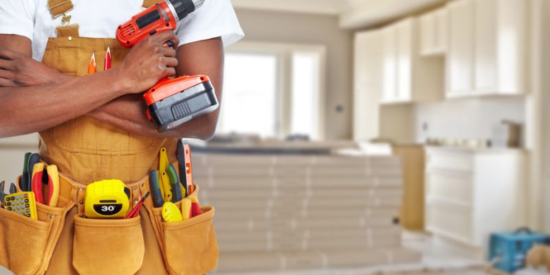 Builder handyman with construction tools. House renovation background.